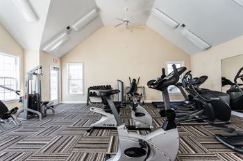 A gym with cardio machines and weights on the floor